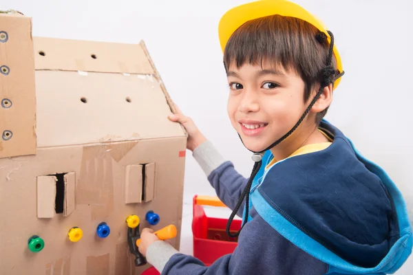 Little boy pretend as a mechanic use tools fix the paper house — Stock Photo, Image