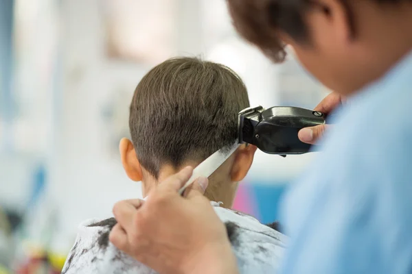 Petit garçon assis pour les cheveux coupés au salon de coiffure — Photo