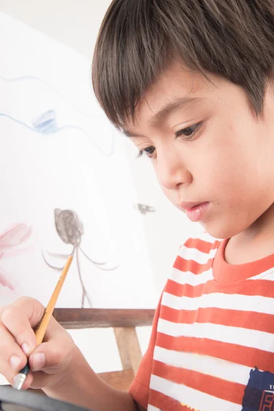 Kleiner Junge zeichnet und malt Bildkunst in der Zeitung — Stockfoto