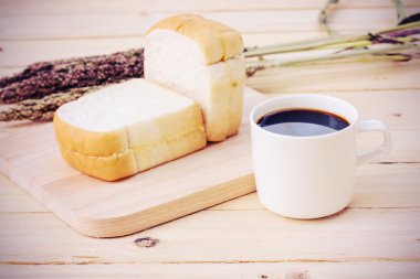 Kahve fincanı ve ahşap zemin üzerinde ekmek