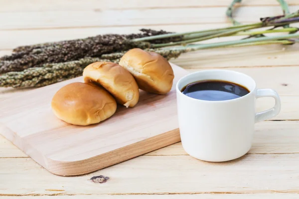 Xícara de café e pão no chão de madeira — Fotografia de Stock
