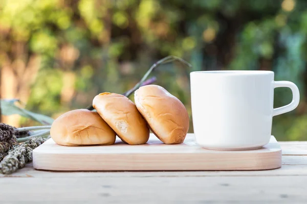 Koffiekopje en brood op houten vloer Rechtenvrije Stockfoto's