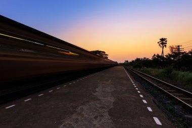 Tren istasyondan günbatımında hareket