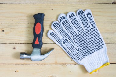 Eldiven ve ahşap zemin üzerinde çekiç