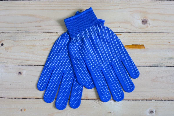 Blue gloves on wooden table