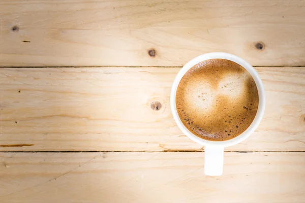 Koffiekopje genomen in bovenaanzicht op houten tafel — Stockfoto