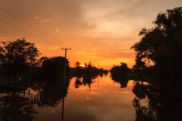 Poste eléctrico en el canal con luz del atardecer — Foto de Stock