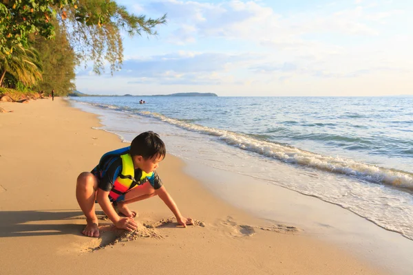 Boy was playing sand on the beach — Stock Photo, Image