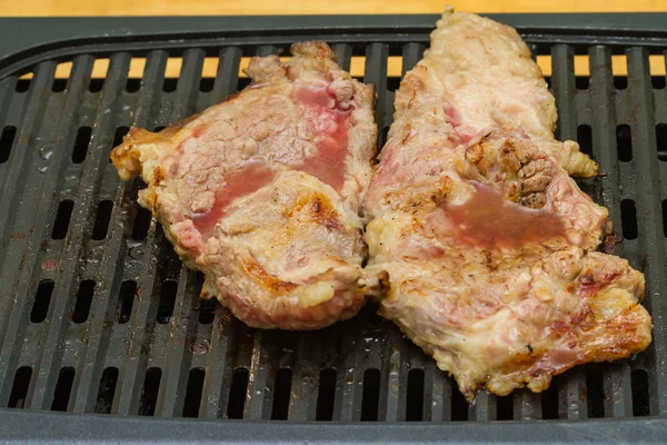 Steak meat grilling on electric barbecue grill — Stock Photo, Image