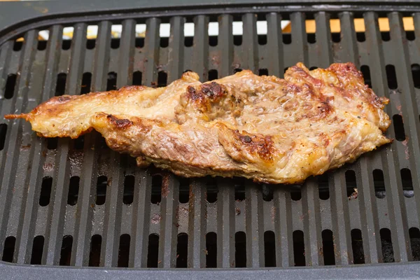 Steak meat grilling on electric barbecue grill — Stock Photo, Image