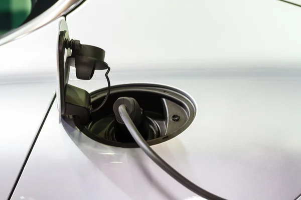 Un coche eléctrico cargando con el cable de alimentación conectado — Foto de Stock