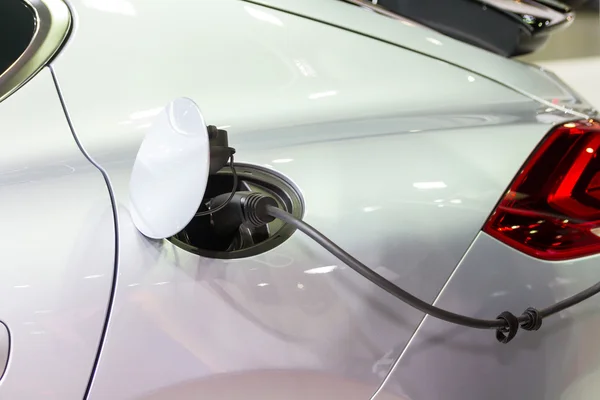 Un coche eléctrico cargando con el cable de alimentación conectado — Foto de Stock