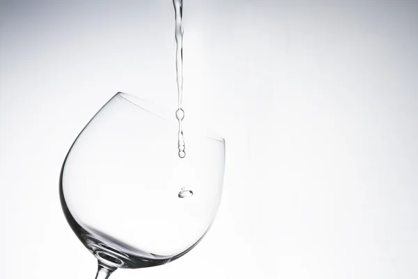 Water drop into wine glass on white background — Stock Photo, Image