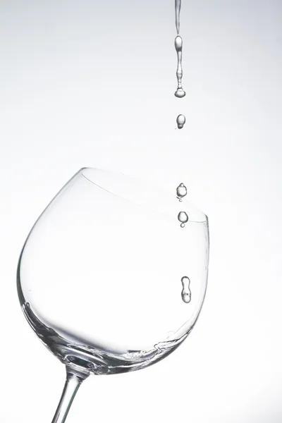 Gota de agua en copa de vino sobre fondo blanco — Foto de Stock