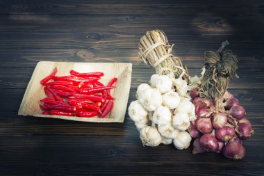 Sarımsak ve kırmızı soğan ve koyu ahşap zemin üzerinde kırmızı biber