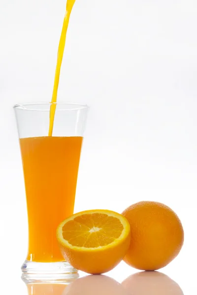 Verse jus d'orange gieten in een glas op wit — Stockfoto