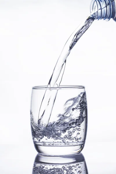 Water pouring into the glass on white — Stock Photo, Image