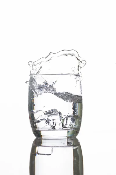 Ice dropping into a glass of water — Stock Photo, Image