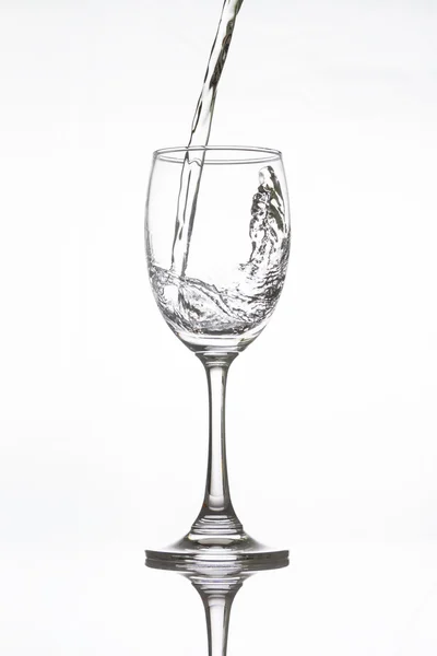 Water gieten in wijnstok glas op wit — Stockfoto