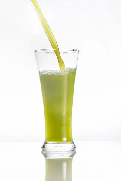 Kiwi juice pouring into a glass on white — Stock Photo, Image