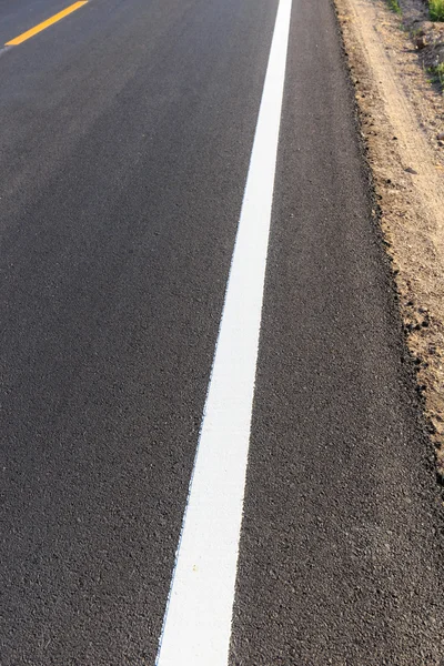 Línea blanca y amarilla en nueva carretera de asfalto — Foto de Stock