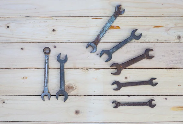 Rusty wrench on white wood — Stock Photo, Image