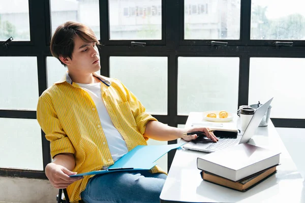 Азиатский Молодой Человек Жёлтой Рубашке Работает Столом Современном Офисе — стоковое фото