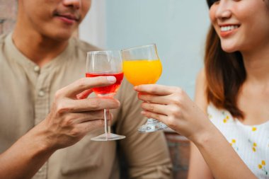 Asyalı çift, restoranda kadeh kaldırarak kutlama yapıyor..