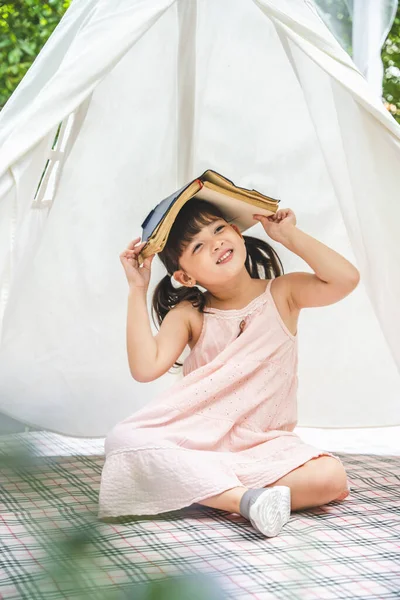 Kafasını Örten Küçük Tatlı Asyalı Kız Bahçedeki Beyaz Çadırda Kalıyor — Stok fotoğraf