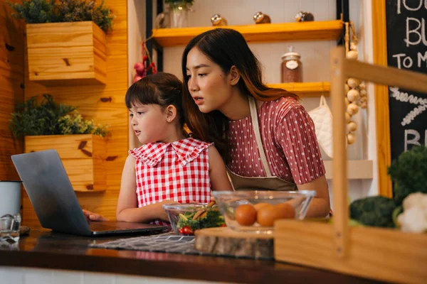 料理をしながら アジアの母親と娘は インターネット上の食品レシピを見て — ストック写真