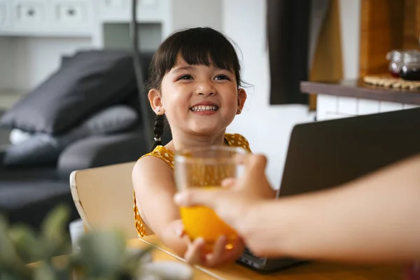 Menina Asiática Tomando Copo Suco Laranja Mãe Enquanto Usa Computador — Fotografia de Stock