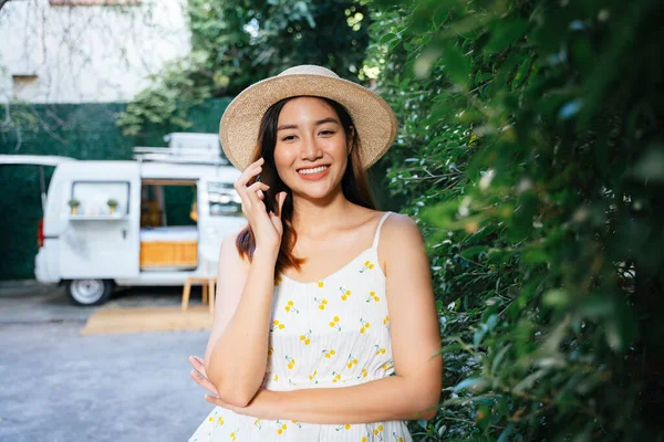 美しいアジアの旅行者の女性は 公園で電話で話す帽子と白いドレスを着用 — ストック写真