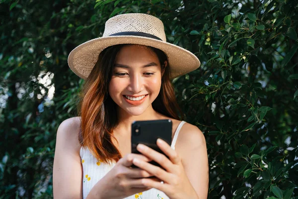 Veselý Šťastný Asijské Žena Nosit Klobouk Chatování Smartphone Venku — Stock fotografie