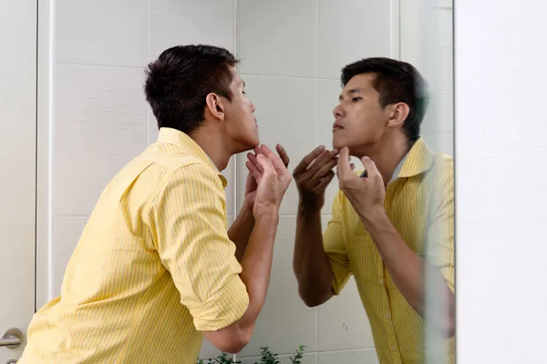 Азиатский Мужчина Проверяет Угревую Сыпь Лице Перед Зеркалом — стоковое фото