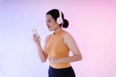 Asyalı bir koşucunun yan görünüm portresi Kulaklıkla müzik dinlemek.