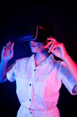 Asyalı kadın oyun veya 3D video ile etkileşen modern VR gözlük takıyor.