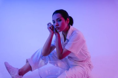 Uzay kasklı, neon ışıklı Asyalı astronot kadın portresi.