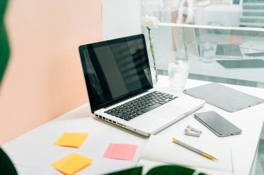 Boş dizüstü bilgisayarı ve dijital aleti olan minimum ofis masası. Boşluğu kopyala ve tasarımı taklit et.
