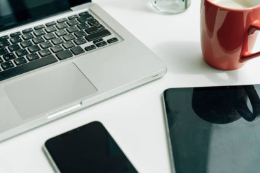 Üst Görünüm - Dizüstü bilgisayarı ve dijital aygıtı olan minimal ofis masası.