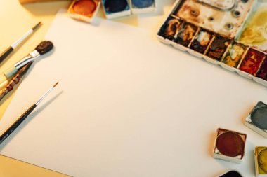 Üst görünüm - Renk boyama ekipmanları ve kağıt masanı ile çalışan sanatçı modeli.