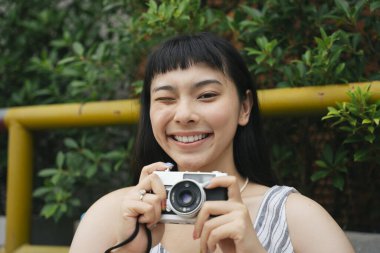 Klasik fotoğraf makinesi olan Asyalı genç bir kadının moda portresi. Resimdeki güzel fotoğrafçı.. 