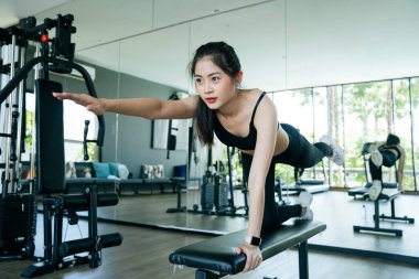 Sağlıklı Asyalı kadın jimnastik salonunda tezgah hazırlıyor..