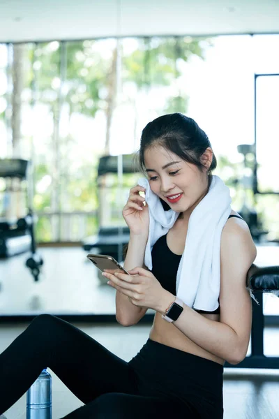 Sağlıklı Asyalı Kadın Spor Salonunda Işten Sonra Akıllı Telefon Kullanıyor — Stok fotoğraf