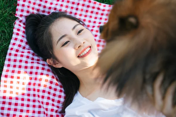 Close up woman owner lift up dog in the air, having fun at park.