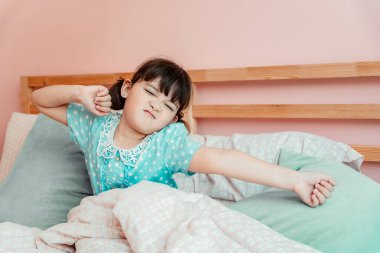 Sevimli kız sabahları yataktan kalkıp ellerini uzatıyor..