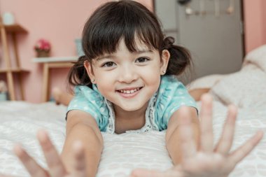 Yatak odasında küçük tatlı bir kızın portresi..