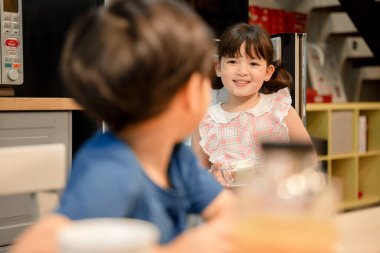 Sevimli kız kardeşi mutfakta yemek pişiriyor..