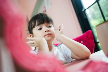 Evde aynanın önünde makyaj yapan tatlı kız..