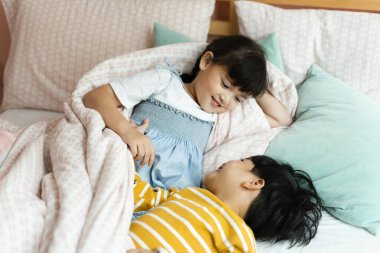 Üst Manzara - Mutlu erkek ve kız yatakta oynuyorlar.