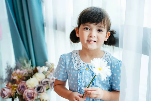 Портрет Милої Маленької Дівчинки Синій Сукні Тримає Білу Квітку Вікні — стокове фото